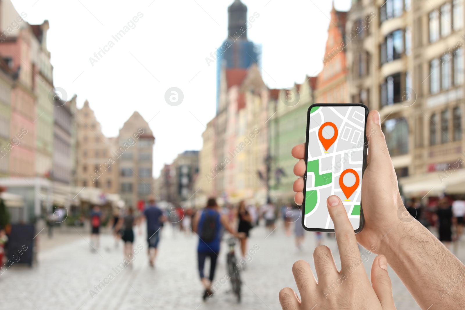 Image of Man searching location with smartphone in city, closeup. Space for text 