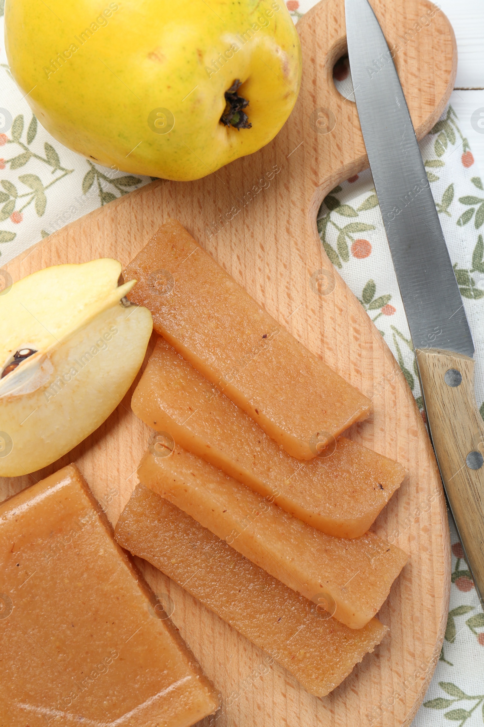 Photo of Tasty sweet quince paste, fresh fruits and knife on table, top view