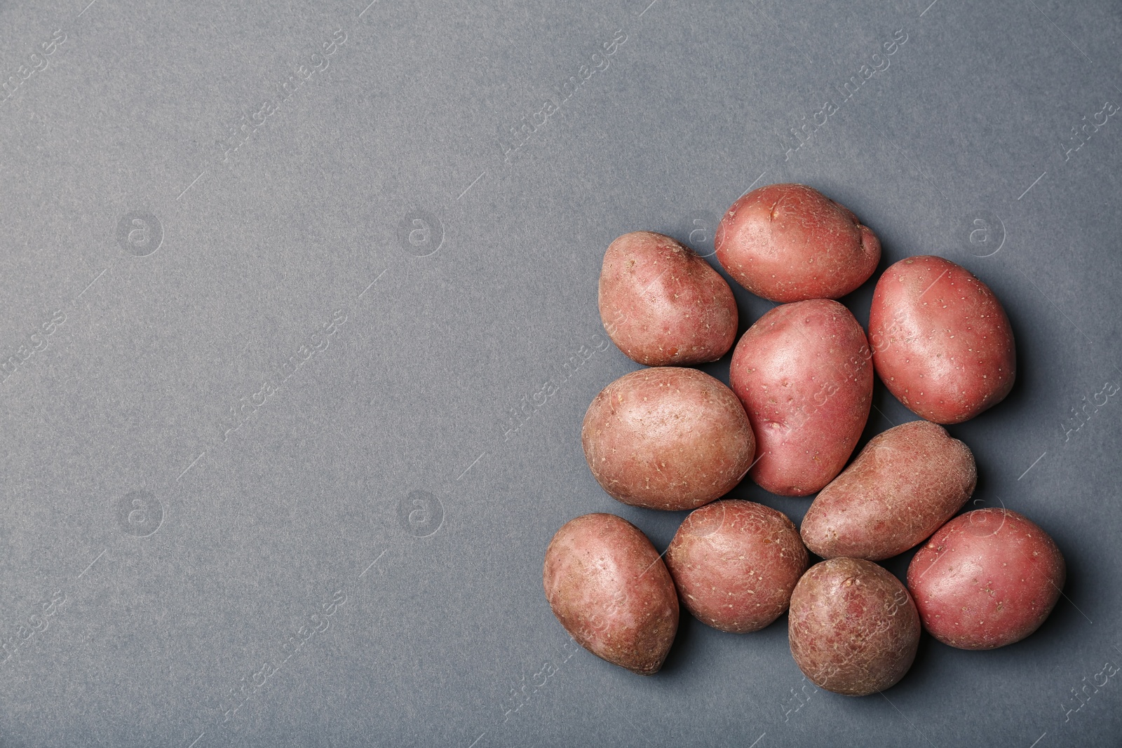 Photo of Flat lay composition with fresh organic potatoes and space for text on grey background