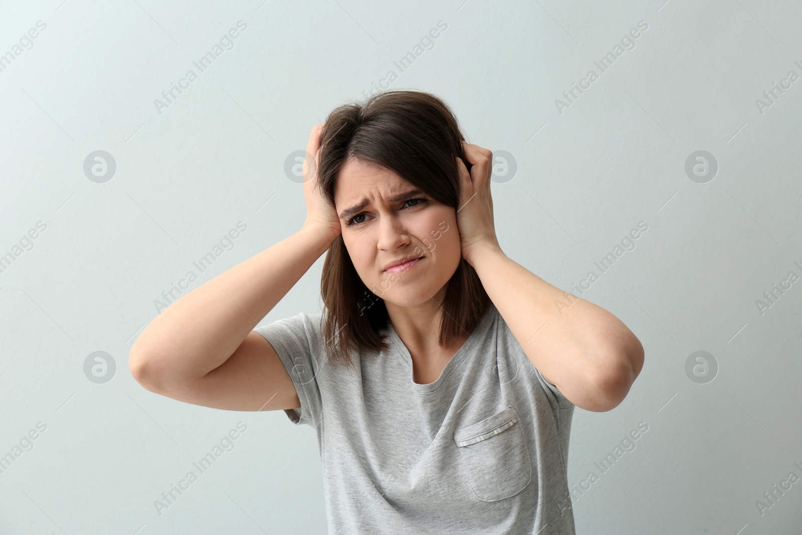 Photo of Young woman suffering from migraine on white background