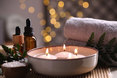 Beautiful composition with different spa products on table against blurred lights, closeup