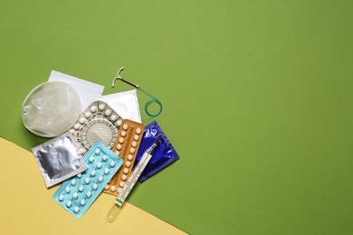 Photo of Contraceptive pills, condoms, intrauterine device and thermometer on color background, flat lay with space for text. Different birth control methods