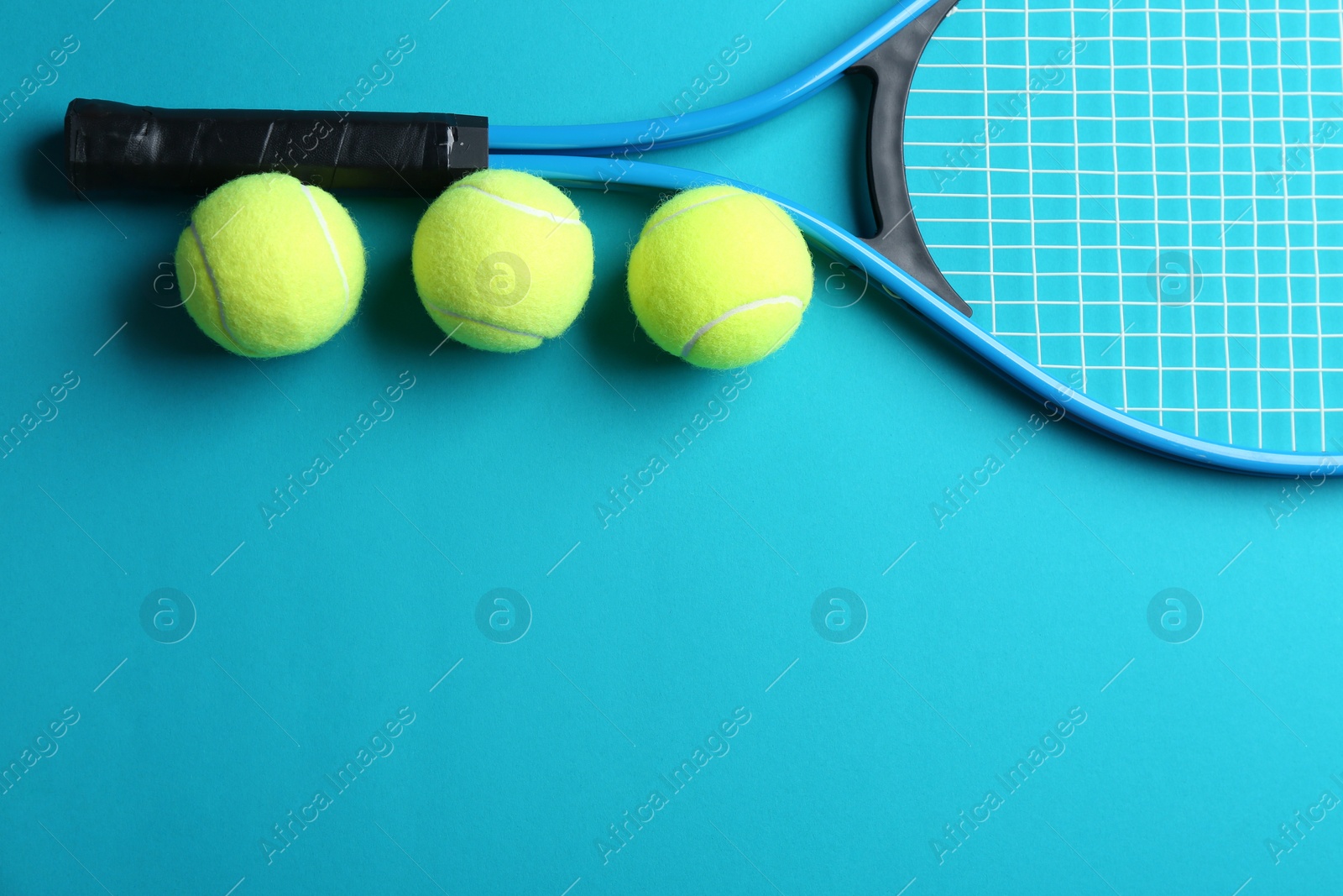 Photo of Tennis racket and balls on blue background, flat lay. Space for text