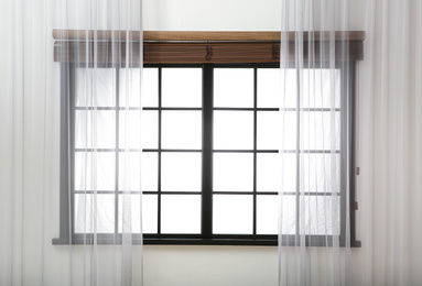 Window with beautiful curtains and open blinds in room