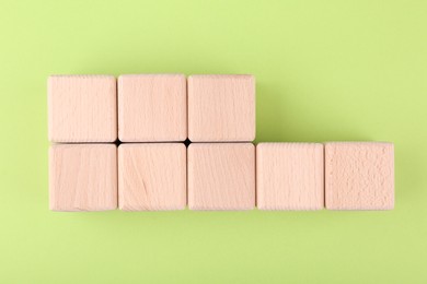 Photo of International Organization for Standardization. Wooden cubes with abbreviation ISO and number 22000 on light green background, flat lay