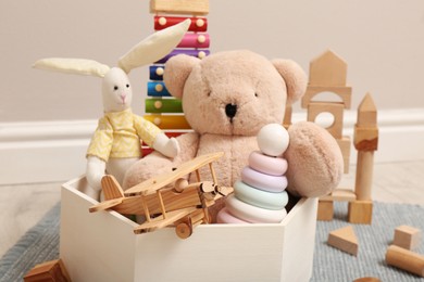 Photo of Set of different toys in box on floor, closeup