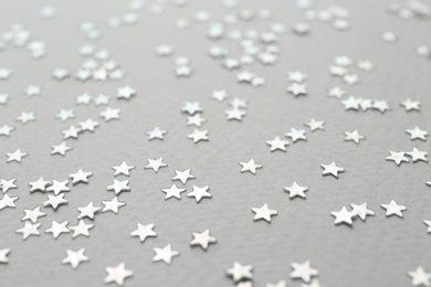 Photo of Confetti stars on grey background, closeup. Christmas celebration