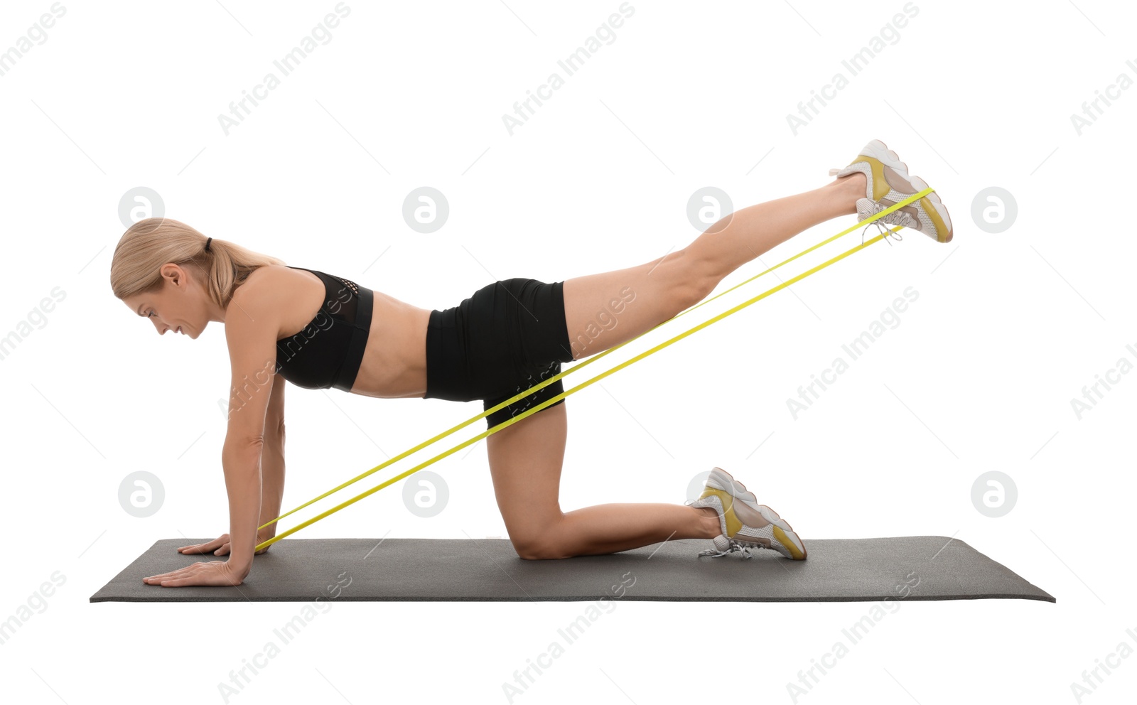 Photo of Woman exercising with elastic resistance band on fitness mat against white background