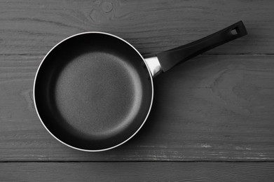 Photo of One frying pan on grey wooden table, top view