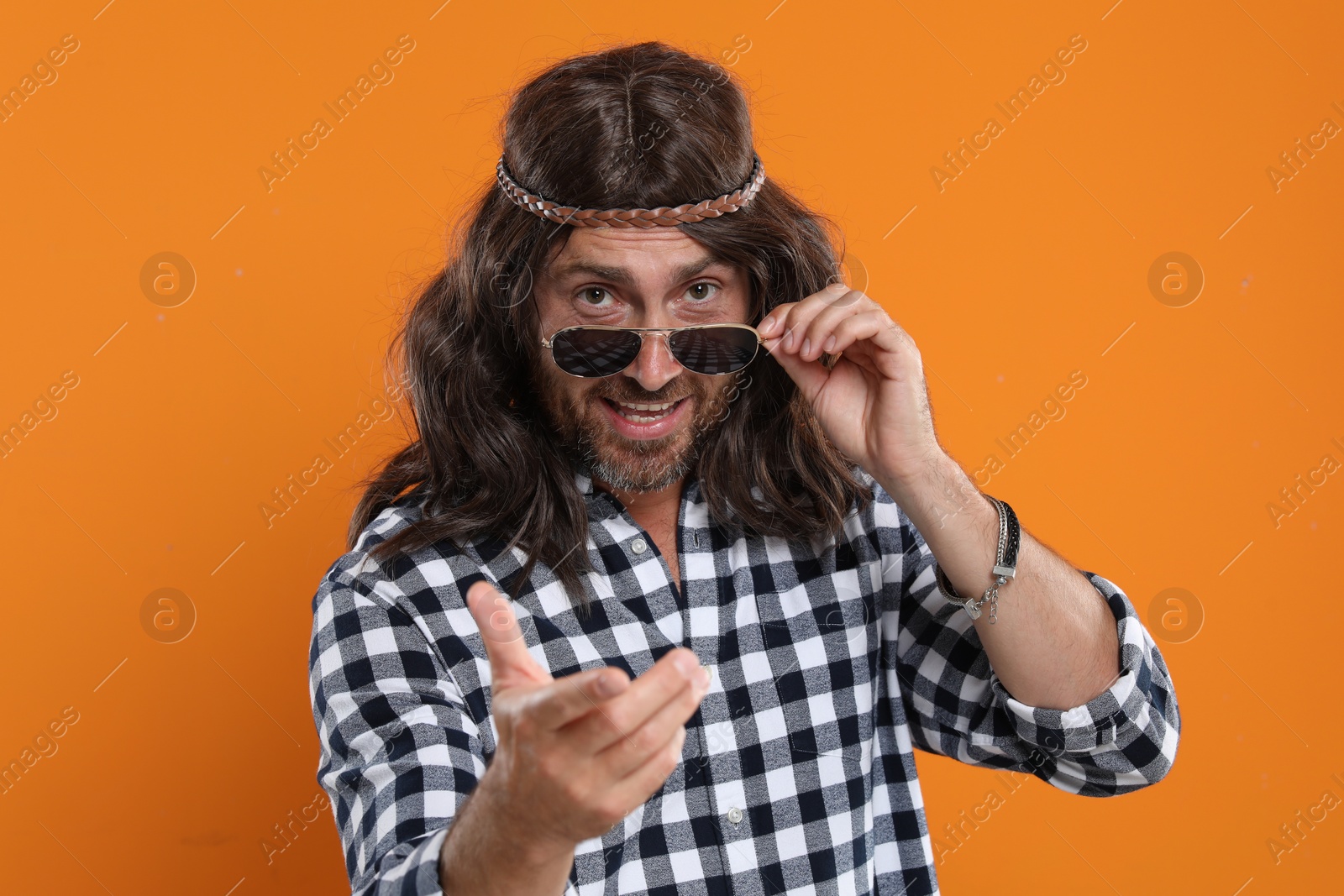 Photo of Hippie man with sunglasses on orange background