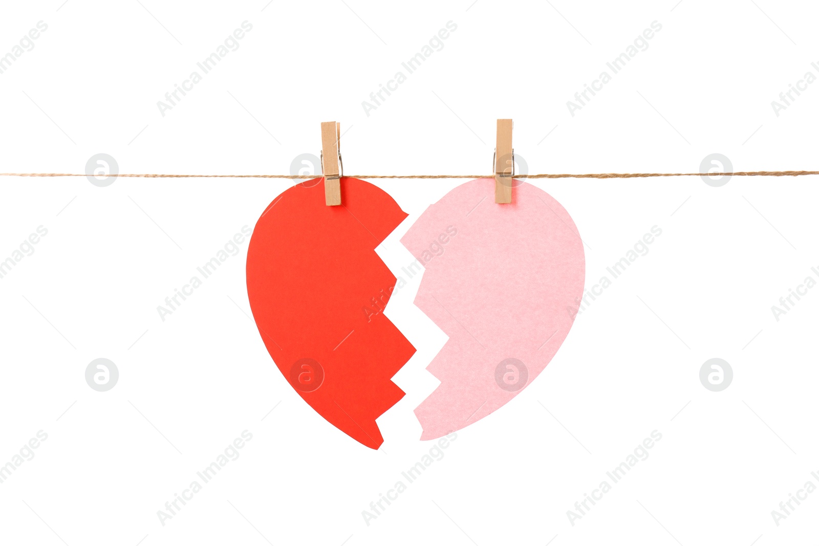 Photo of Halves of paper heart hanging on rope against white background. Relationship problems