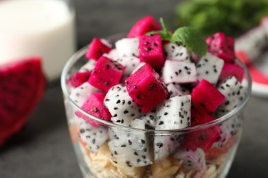 Glass of granola with different pitahayas on table, closeup