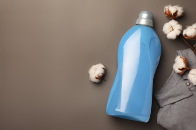 Photo of Bottle of fabric softener, shirt and beautiful cotton flowers on gray background, flat lay. Space for text