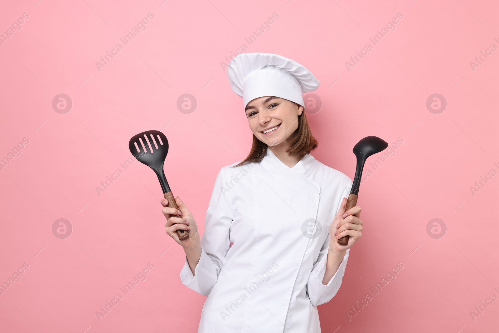 Photo of Professional chef with skimmer and ladle on pink background