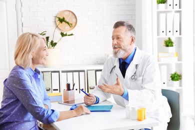 Photo of Mature doctor consulting patient in clinic