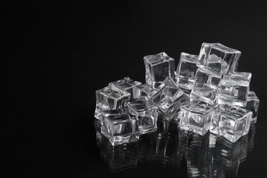 Photo of Crystal clear ice cubes on black background