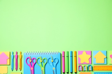 Photo of Different school stationery on green background, flat lay. Space for text