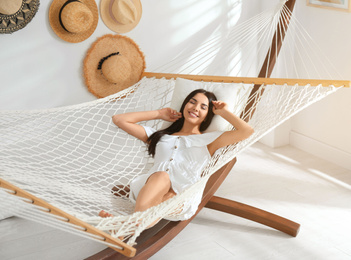 Photo of Young woman relaxing in hammock at home