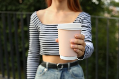 Photo of Coffee to go. Woman with paper cup of drink outdoors, selective focus