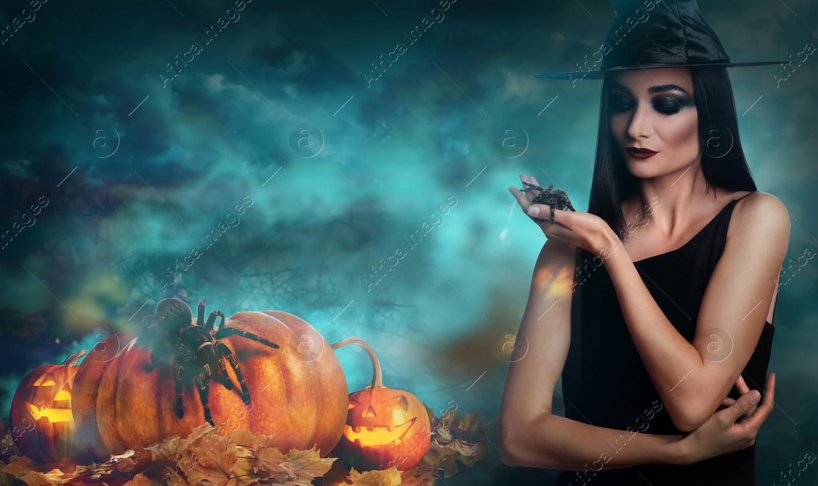 Image of Young girl dressed as witch with creepy spider in misty forest at night. Halloween fantasy