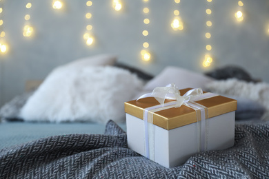 Photo of Christmas gift box on bed in festive interior