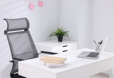 Photo of Desk and comfortable chair in modern office. Interior design