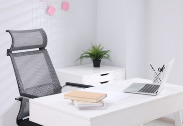 Desk and comfortable chair in modern office. Interior design