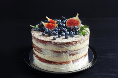 Photo of Delicious homemade cake with fresh berries on dark wooden table