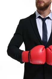 Photo of Businessman in suit wearing boxing gloves on white background, closeup