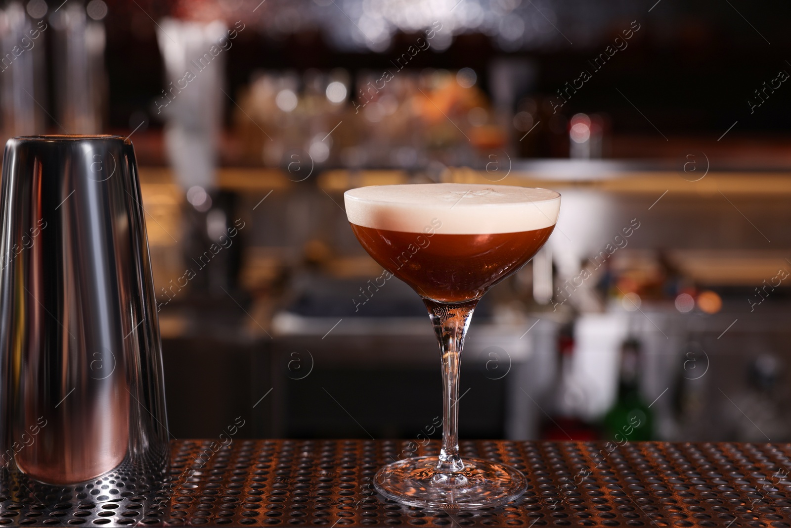 Photo of Glass of delicious Espresso Martini on bar counter. Alcoholic cocktail