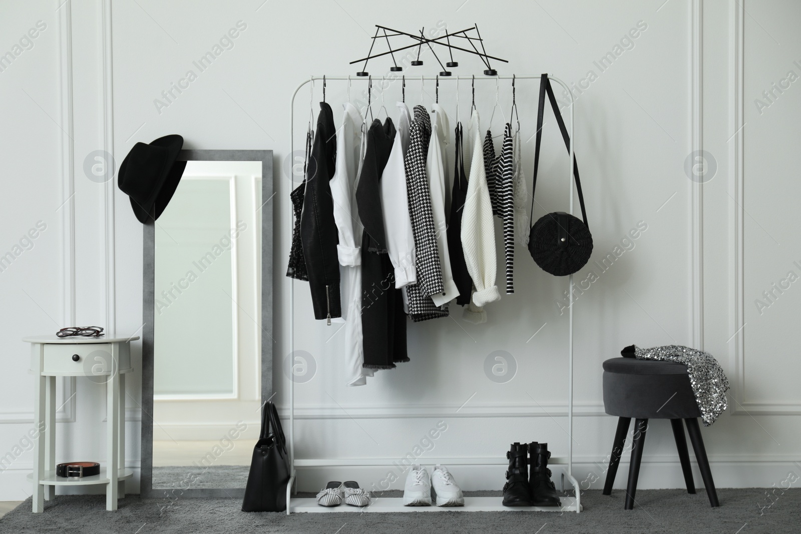 Photo of Rack with stylish clothes in modern dressing room