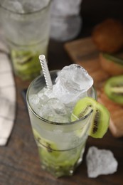 Photo of Glass of refreshing drink with kiwi on table, closeup