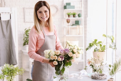 Photo of Female florist with roses at workplace