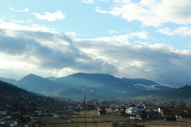 Photo of Picturesque view of beautiful valley with houses in mountains under cloudy sky