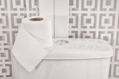 Photo of Roll of paper on toilet tank in bathroom, closeup