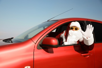 Authentic Santa Claus driving modern car outdoors