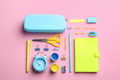 Photo of Bright school stationery on pink background, flat lay