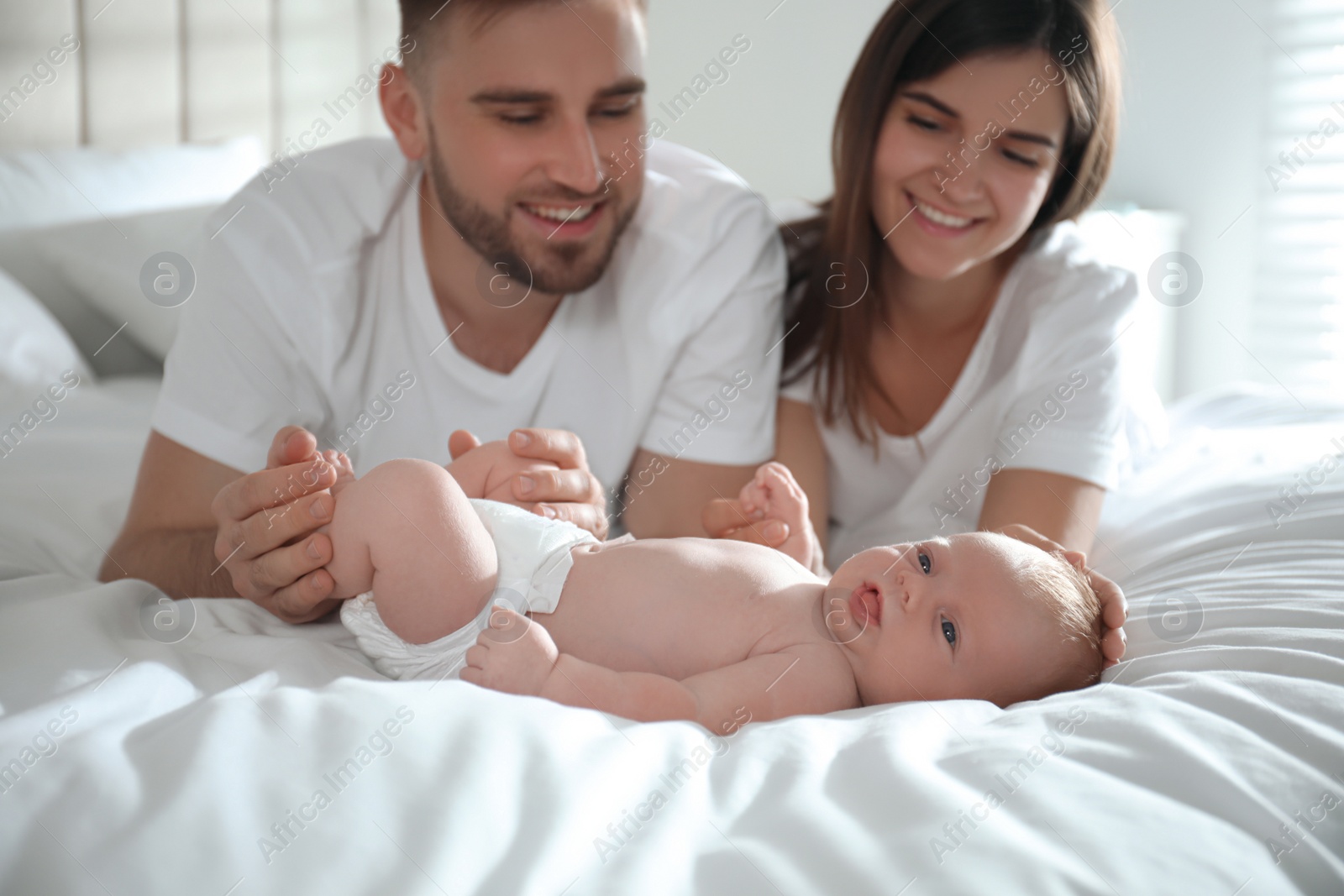 Photo of Happy couple with their newborn baby at home