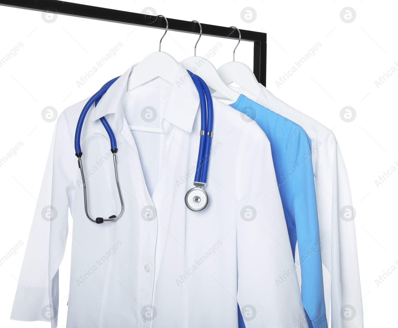 Photo of Doctor's gown with stethoscope and different medical uniforms on rack against white background