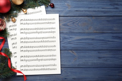 Photo of Flat lay composition with Christmas music sheets on blue wooden background, space for text