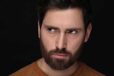 Photo of Evil eye. Man with scary eyes on black background, closeup