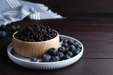 Photo of Freeze dried and fresh blueberries on wooden table. Space for text
