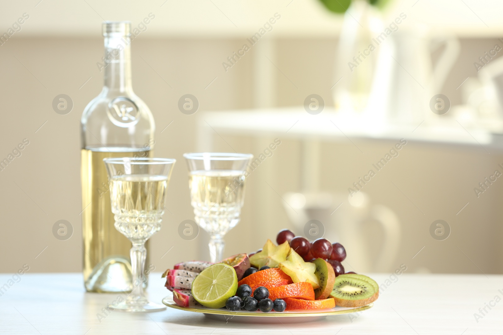 Photo of Delicious exotic fruits and wine on white table