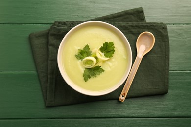Delicious leek soup served on green wooden table, top view