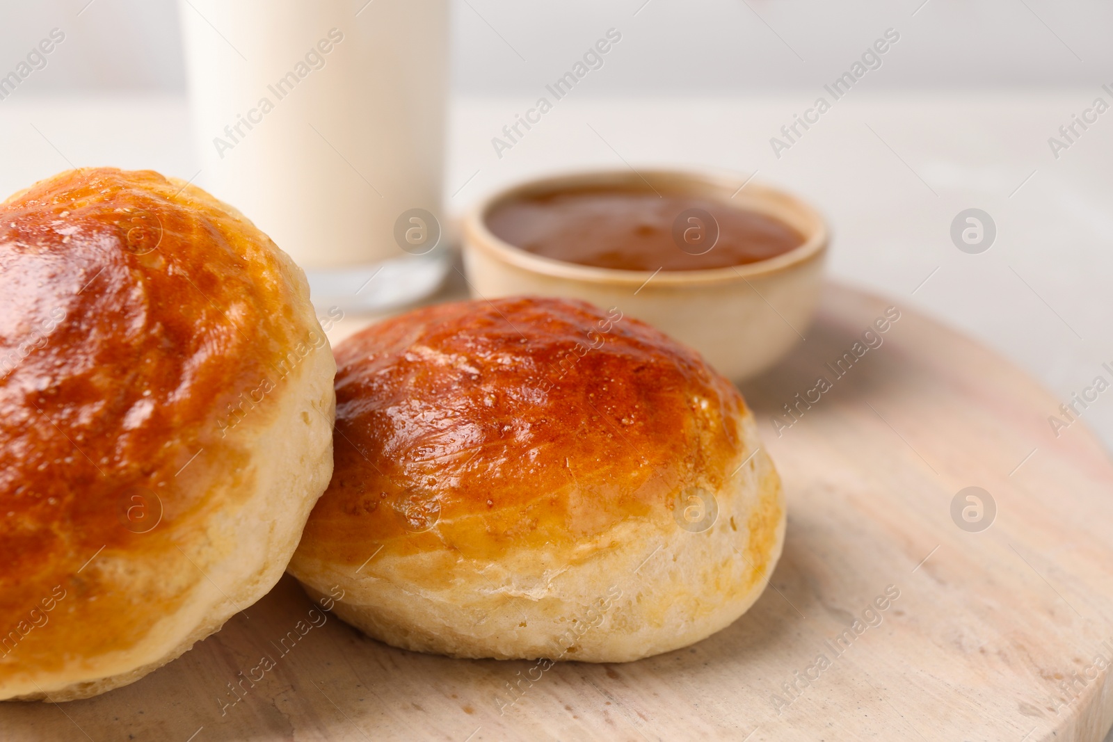 Photo of Freshly baked soda water scones on wooden table, closeup. Space for text