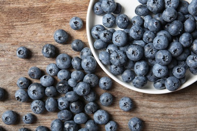 Photo of Flat lay composition with juicy and fresh blueberries on wooden table