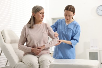 Photo of Arthritis symptoms. Doctor examining patient's elbow in hospital