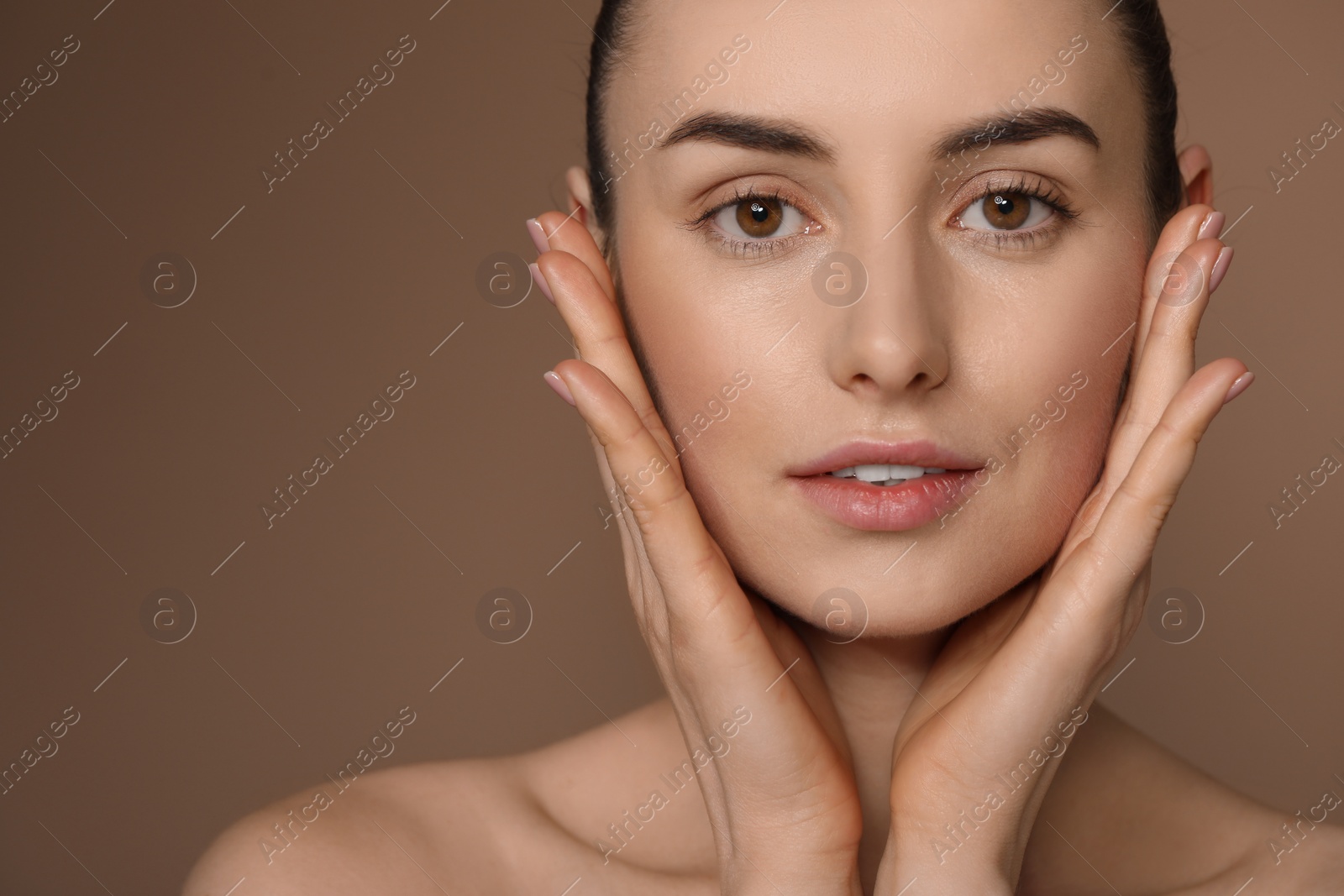 Photo of Beautiful young woman with healthy skin on brown background, closeup. Space for text