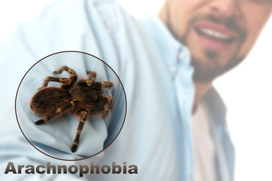 Image of Closeup view of scared man with tarantula, focus on spider. Arachnophobia 