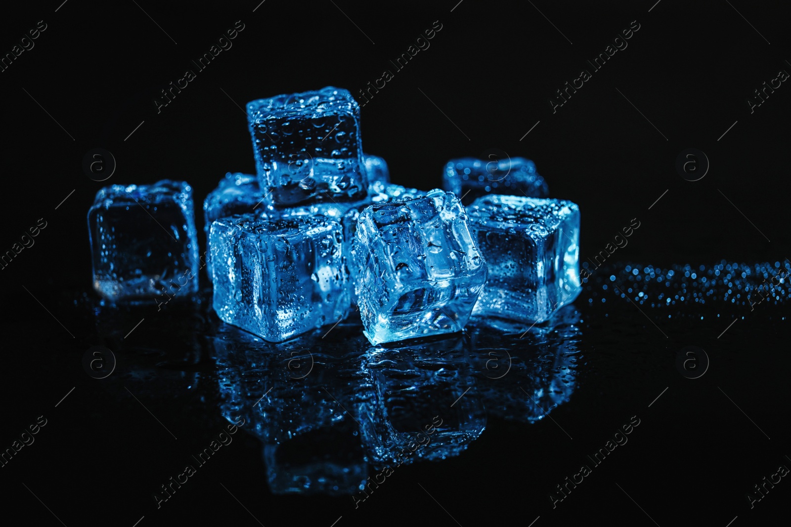 Photo of Pile of crystal clear ice cubes on black background